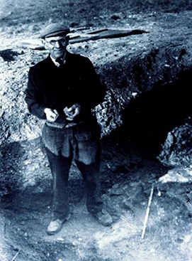 black and white photo of Basil Brown standing in trench