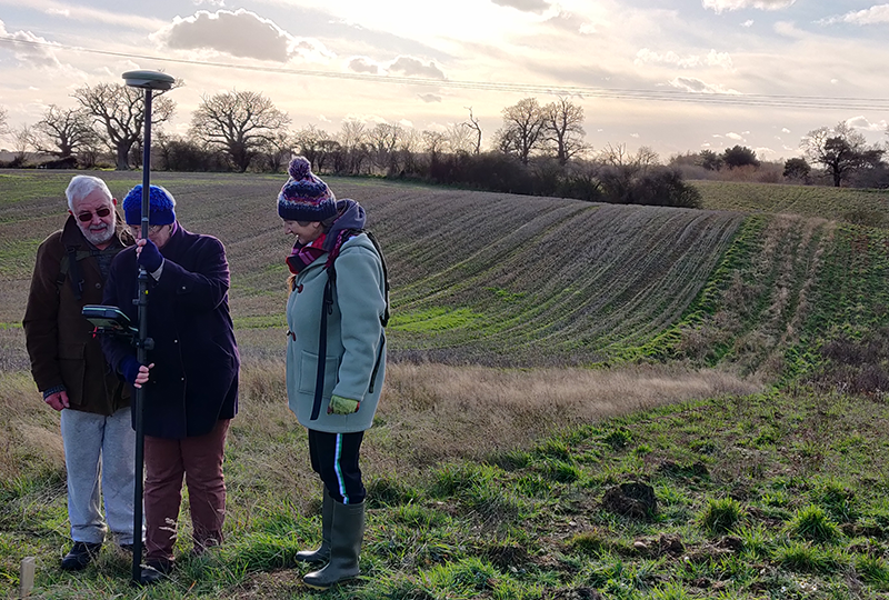 three people in field with GPS