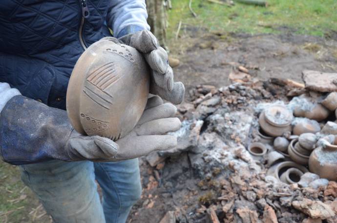 person holding decorated pot