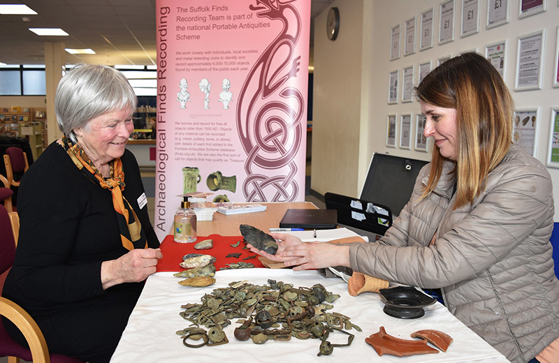 two people looking at Neolithic hand axe