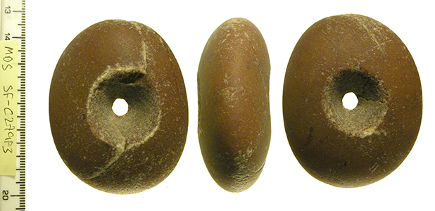 an ovoid pebble macehead with perforation through the centre, image shows 3 sides