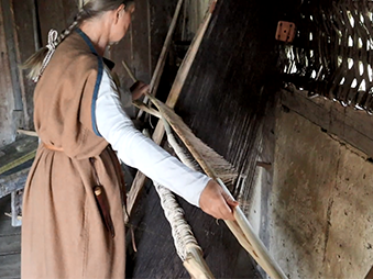 person weaving using a loom