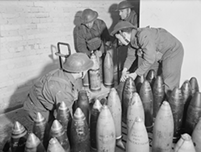 staged wartime photo of med sorting ordnance