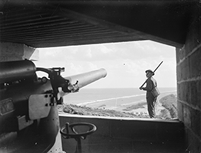 Staged propaganda photograph taken from inside the right hand gunhouse of the Minsmere battery, 1941