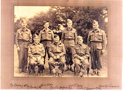 war photo of four officers standing with three Home Guard men sitting